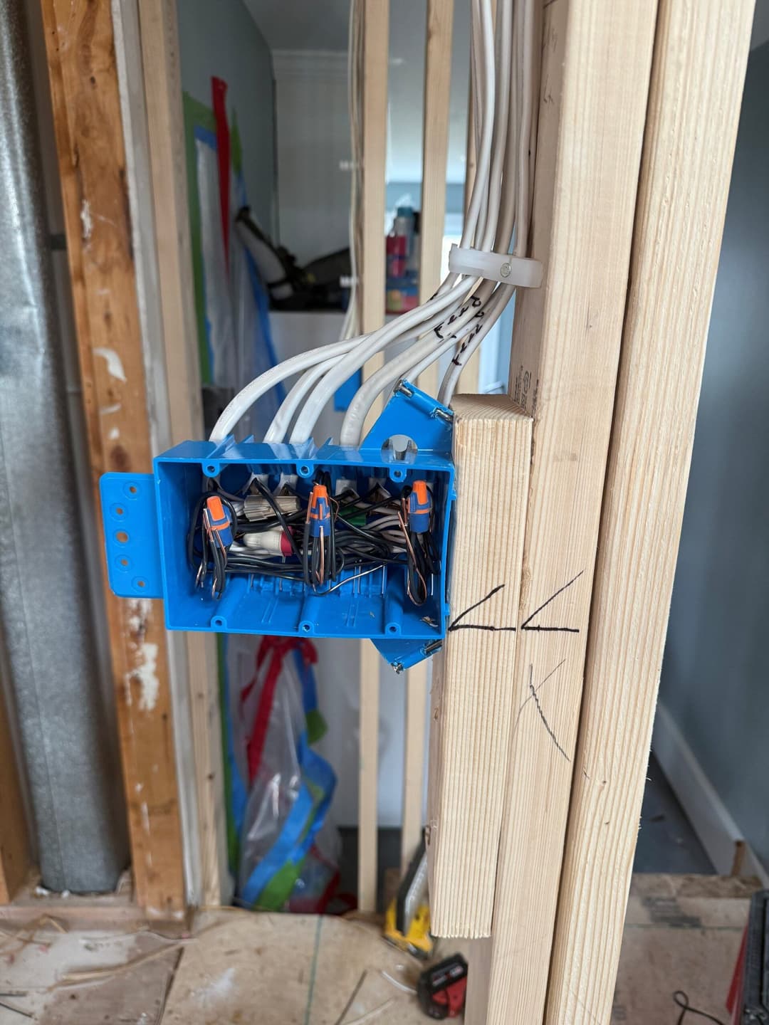 Electrical junction box mounted on wooden framing in a construction site.