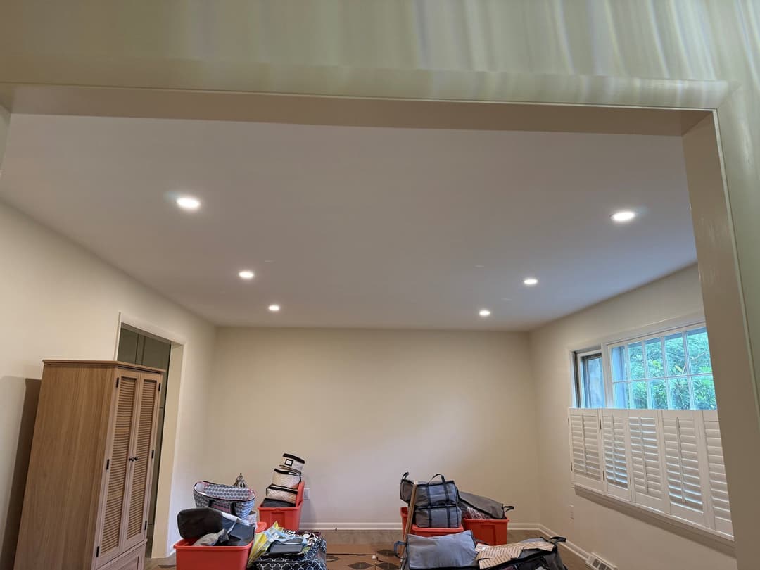 Brightly lit room featuring recessed lighting, storage boxes, and a beige color scheme.