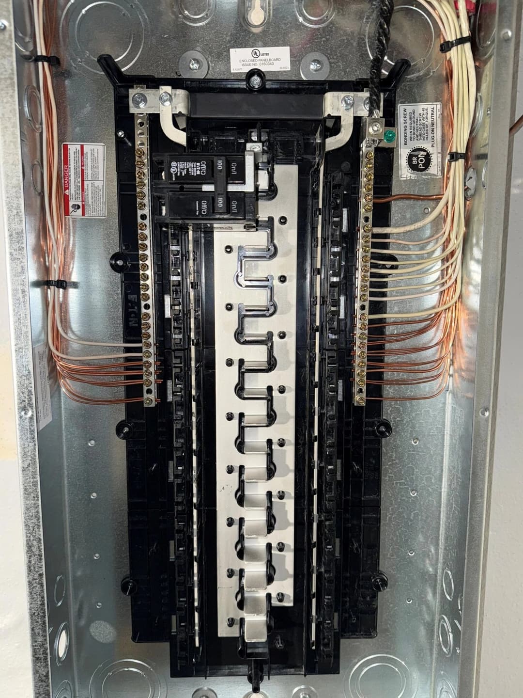 Electrical panel with circuit breakers and wiring, showcasing home electrical system setup.