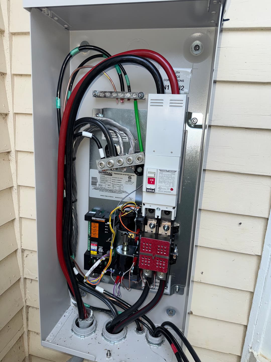 Electrical panel with wiring, circuit breakers, and components mounted on a wall.